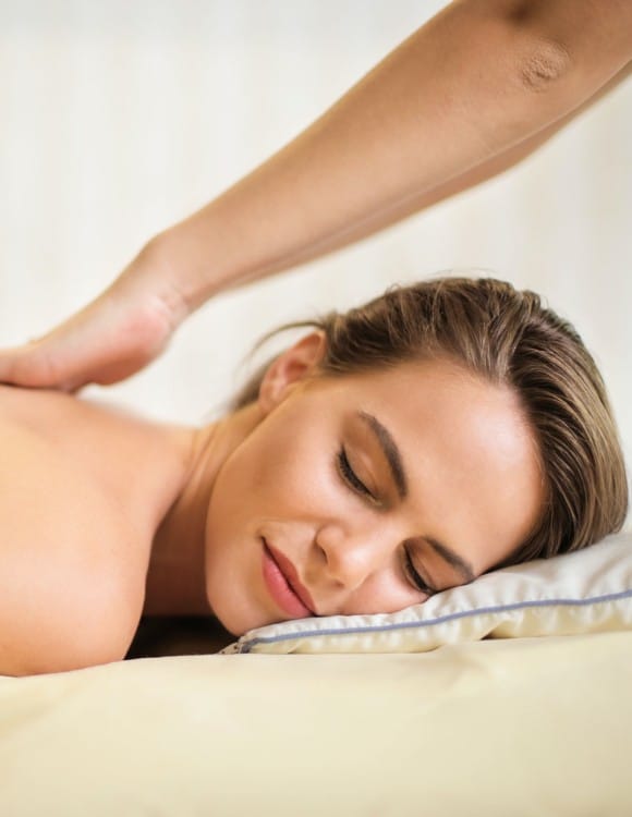 topless-woman-lying-on-bed-getting-massage-3757952-1