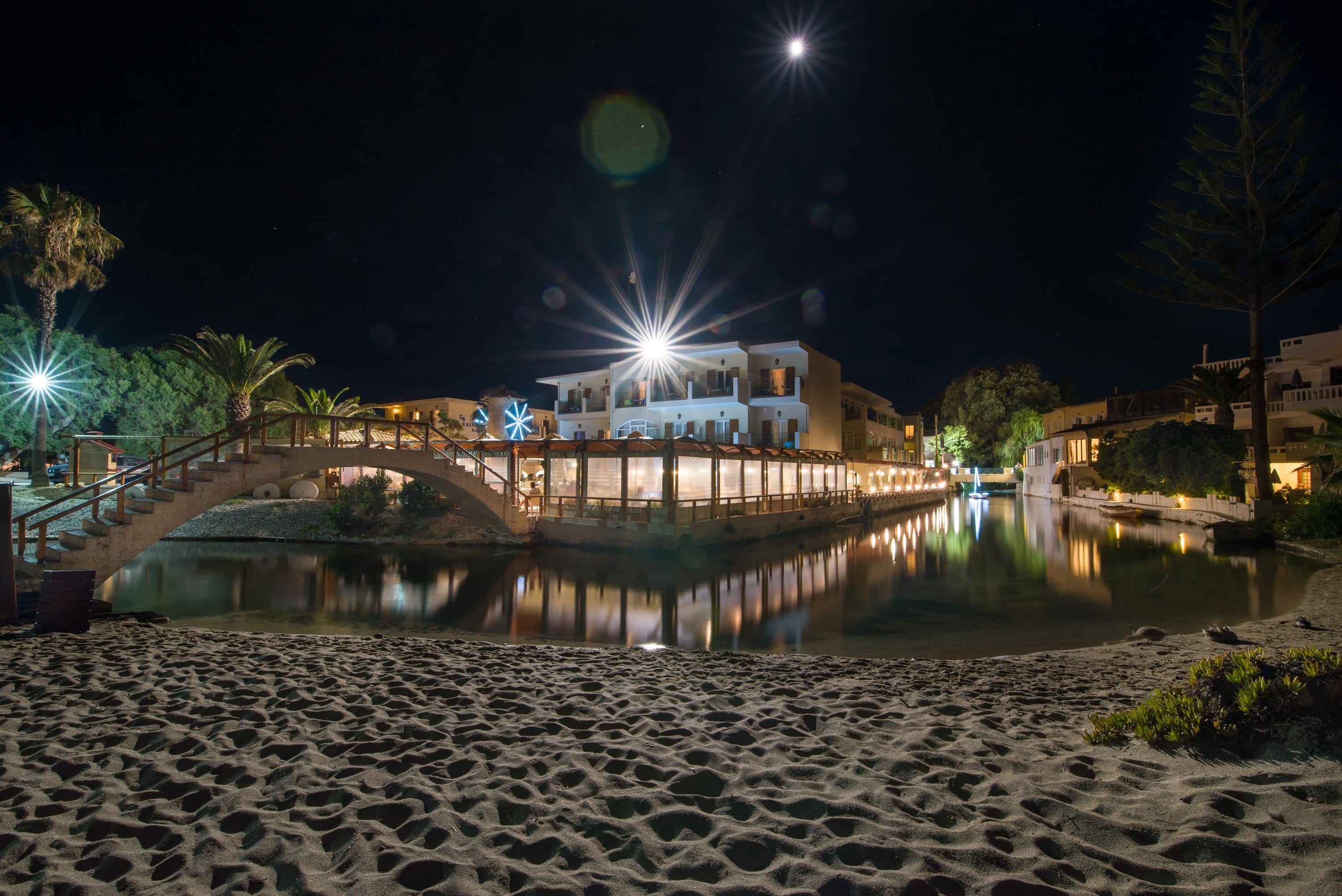 a building with a pool and a bridge at night