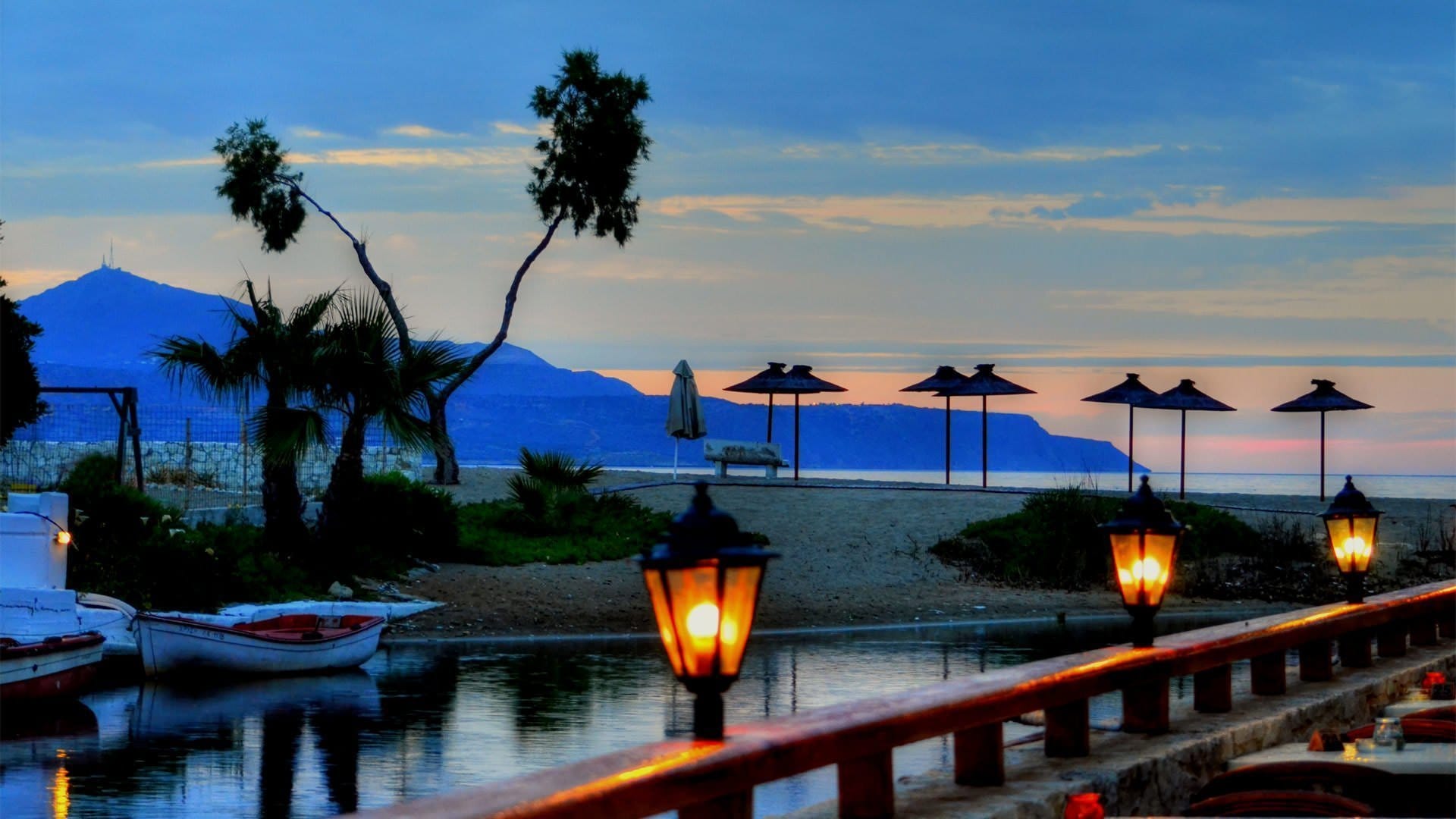 a group of umbrellas on a deck by a body of water