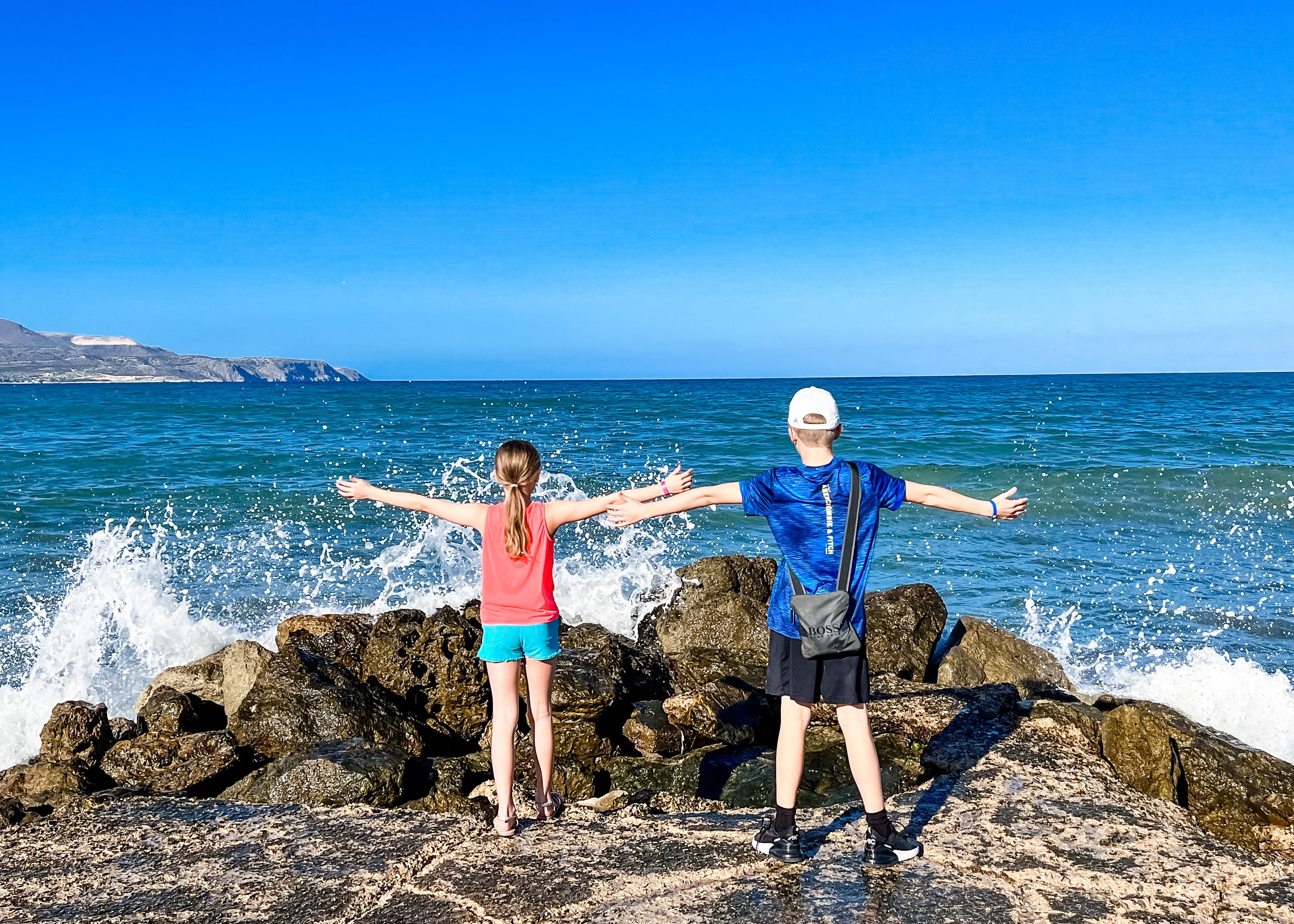 a man and woman posing on a rocky beach