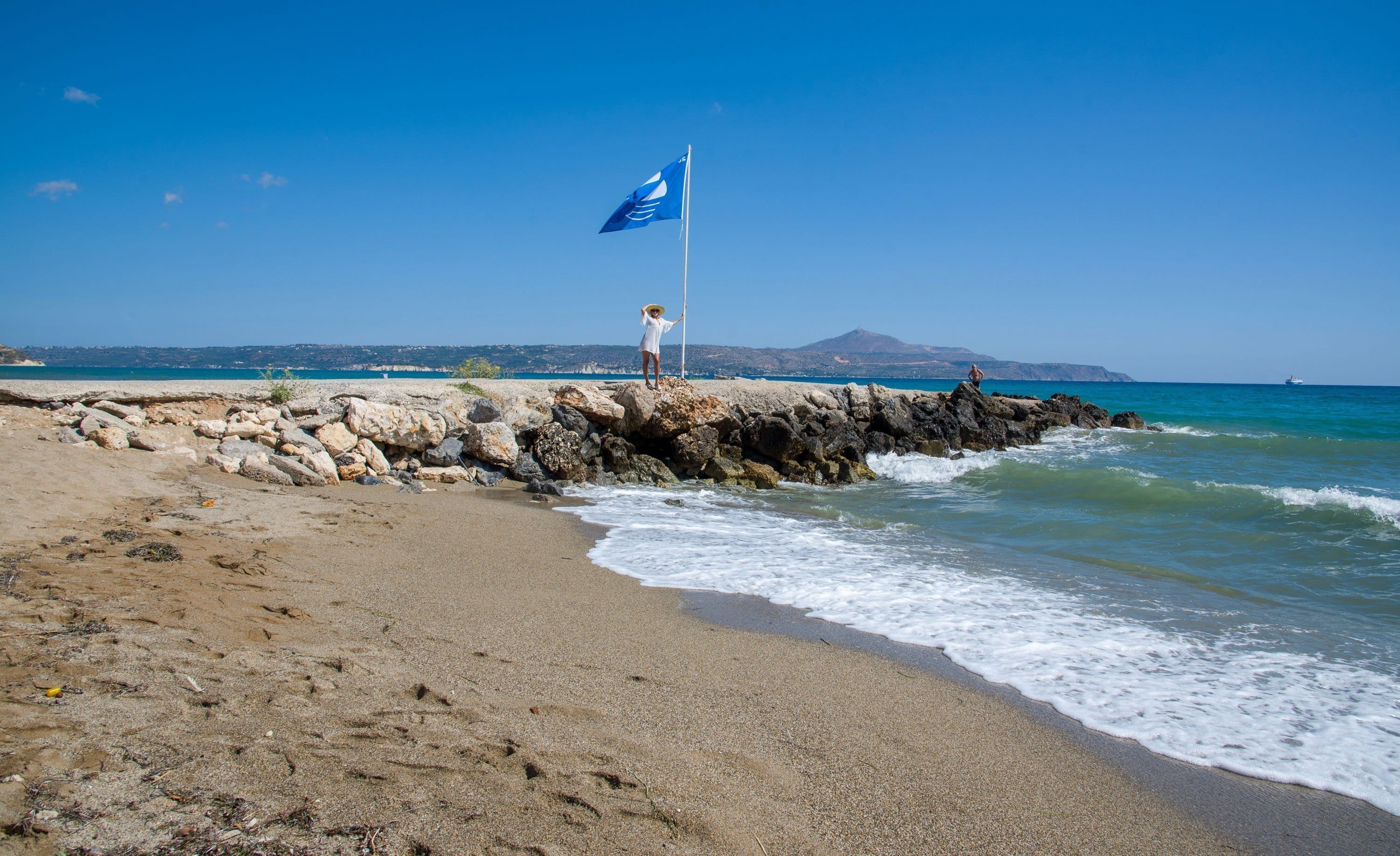 a person standing on a beach with a flag