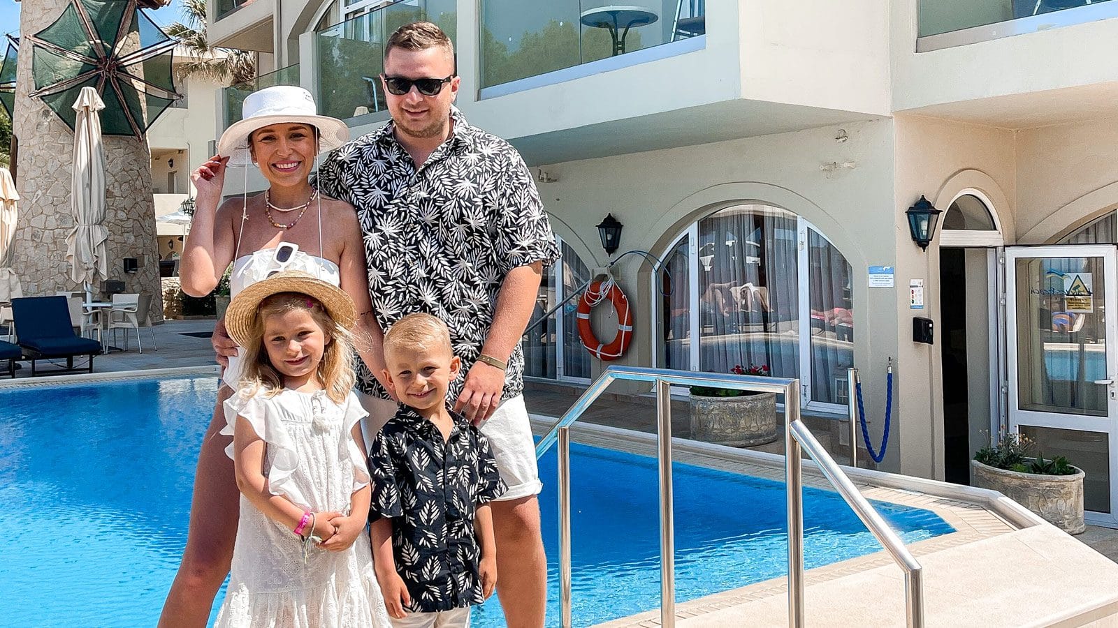 a group of people posing for a photo by a pool