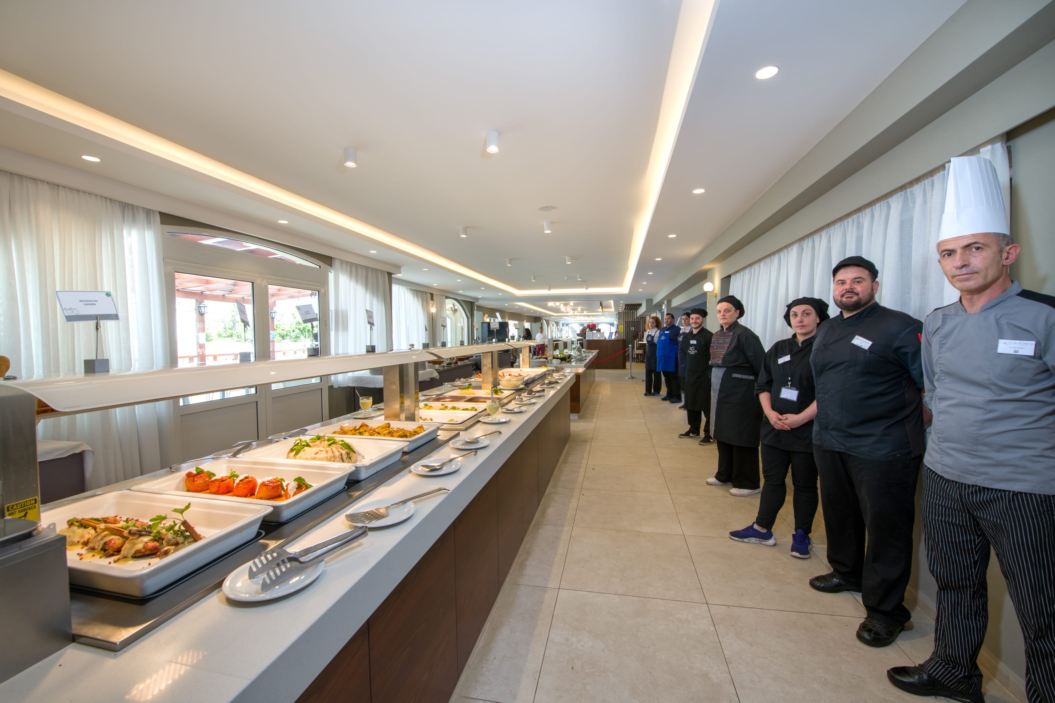 a group of people standing in a room with food on the counter