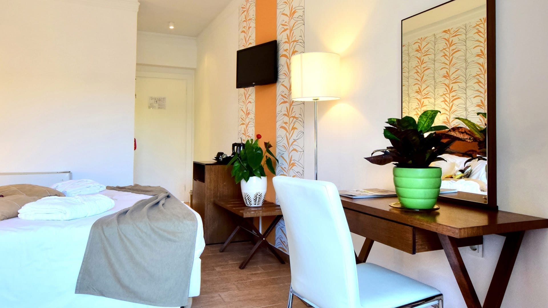 a room with a bed and a desk with a chair and a lamp