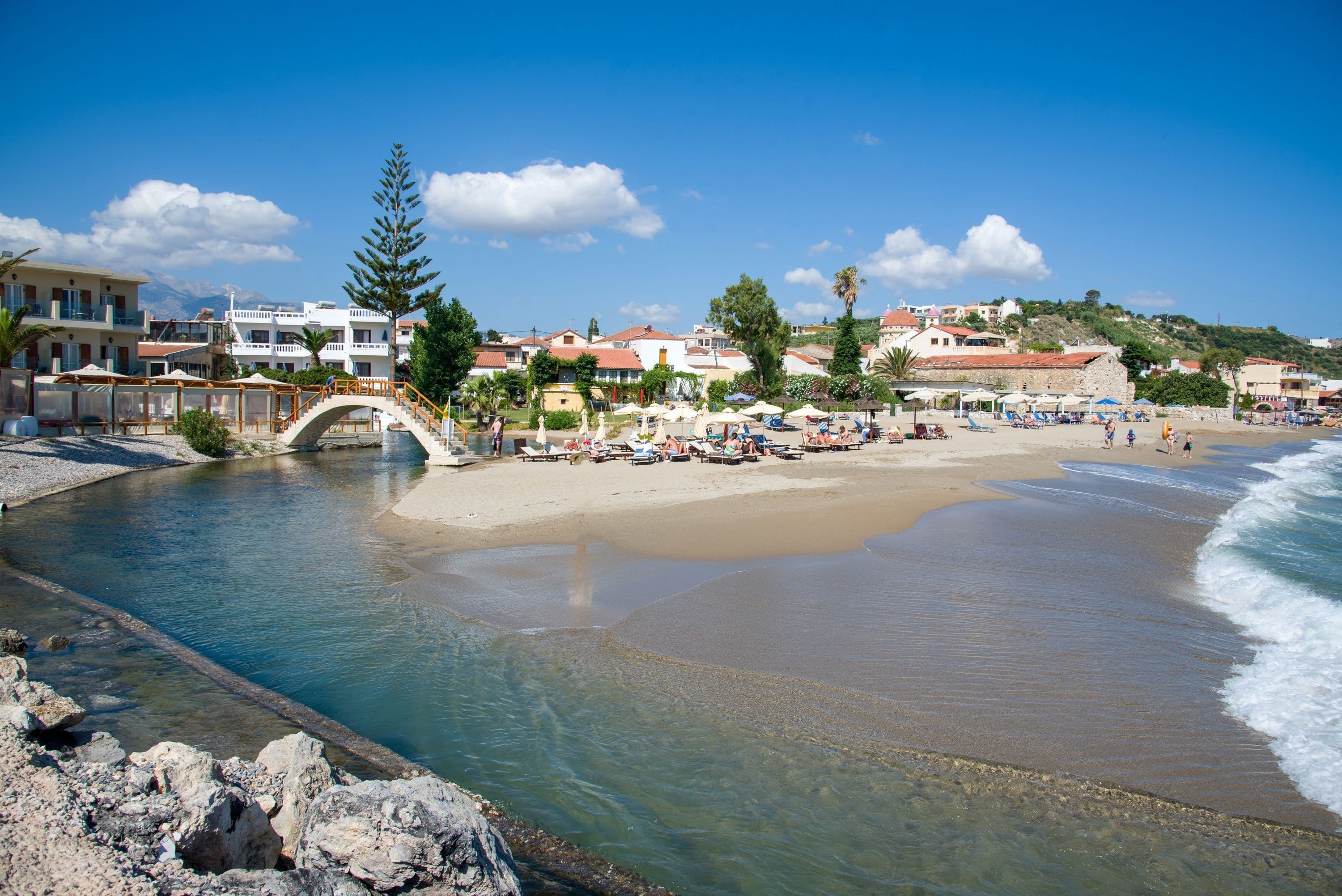 a beach with a bridge and buildings
