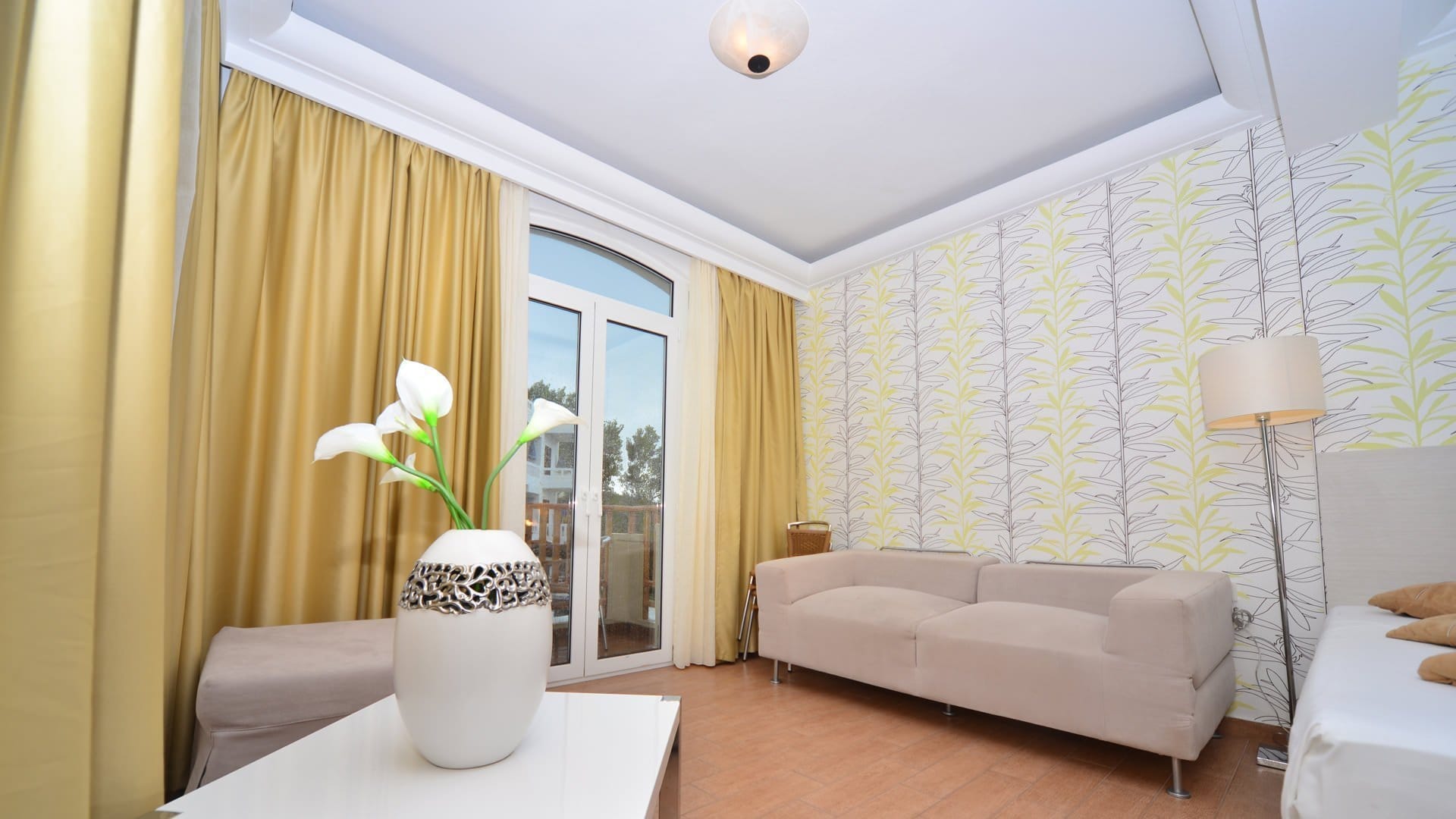 a room with a couch and a table with a vase with flowers