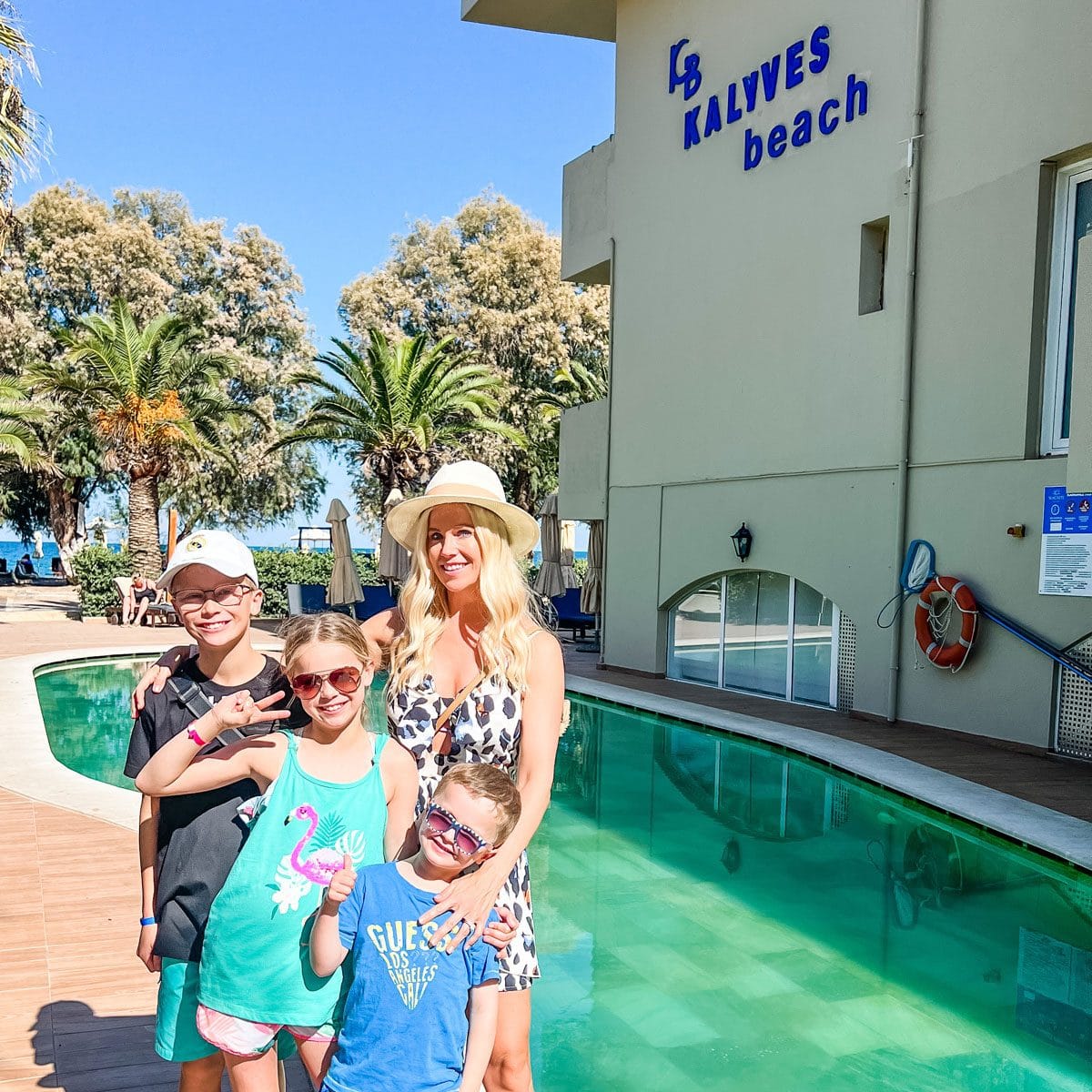 a group of people posing for a photo next to a pool