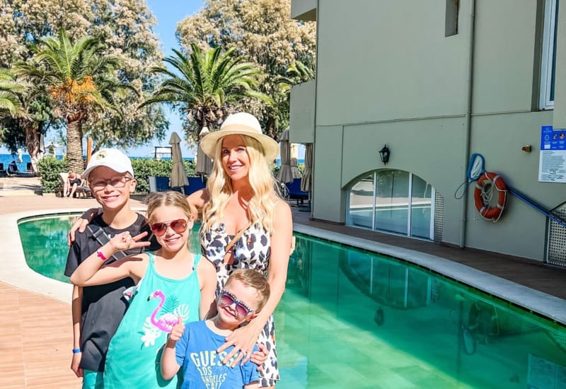a group of people posing for a photo next to a pool