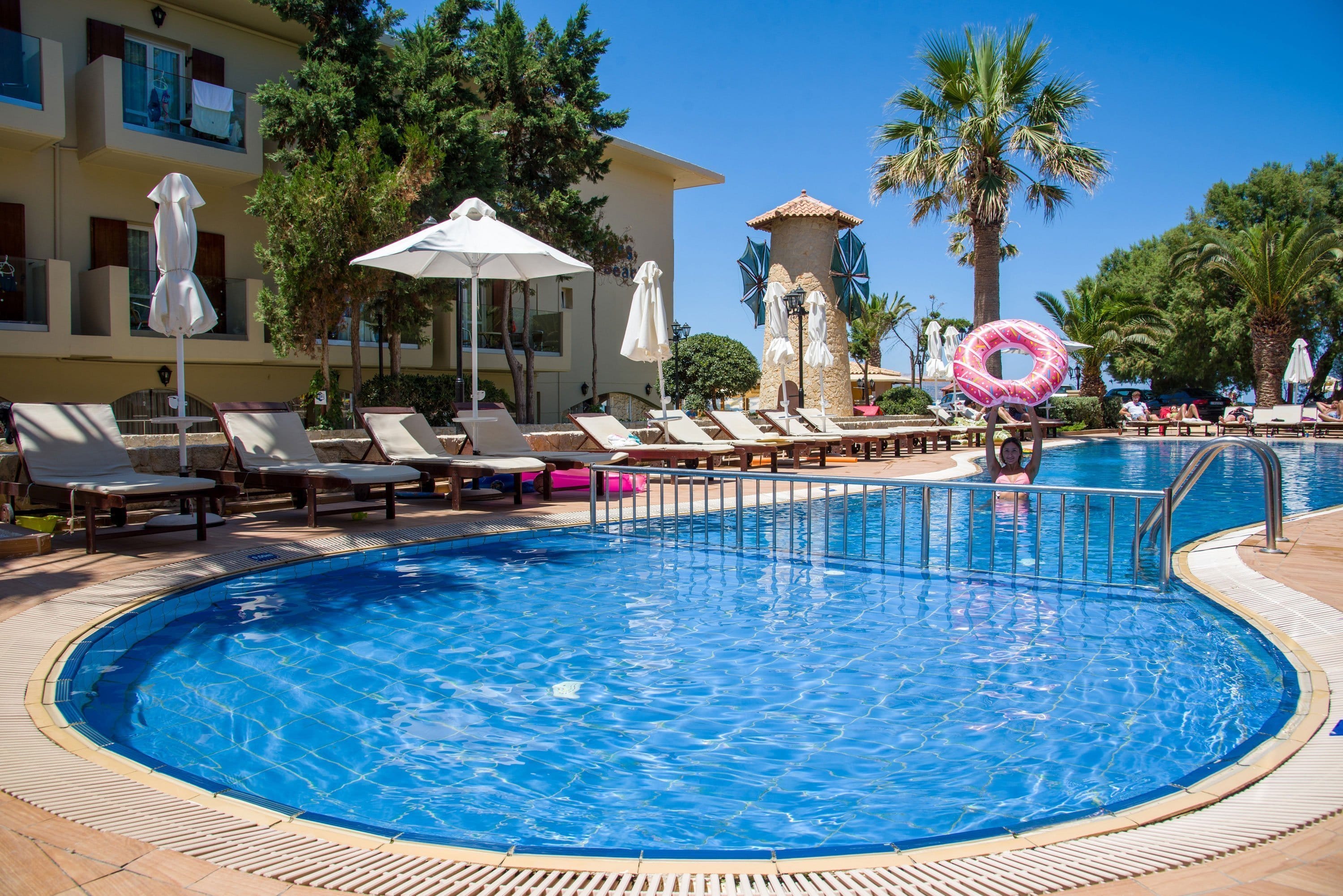 a pool with chairs and umbrellas
