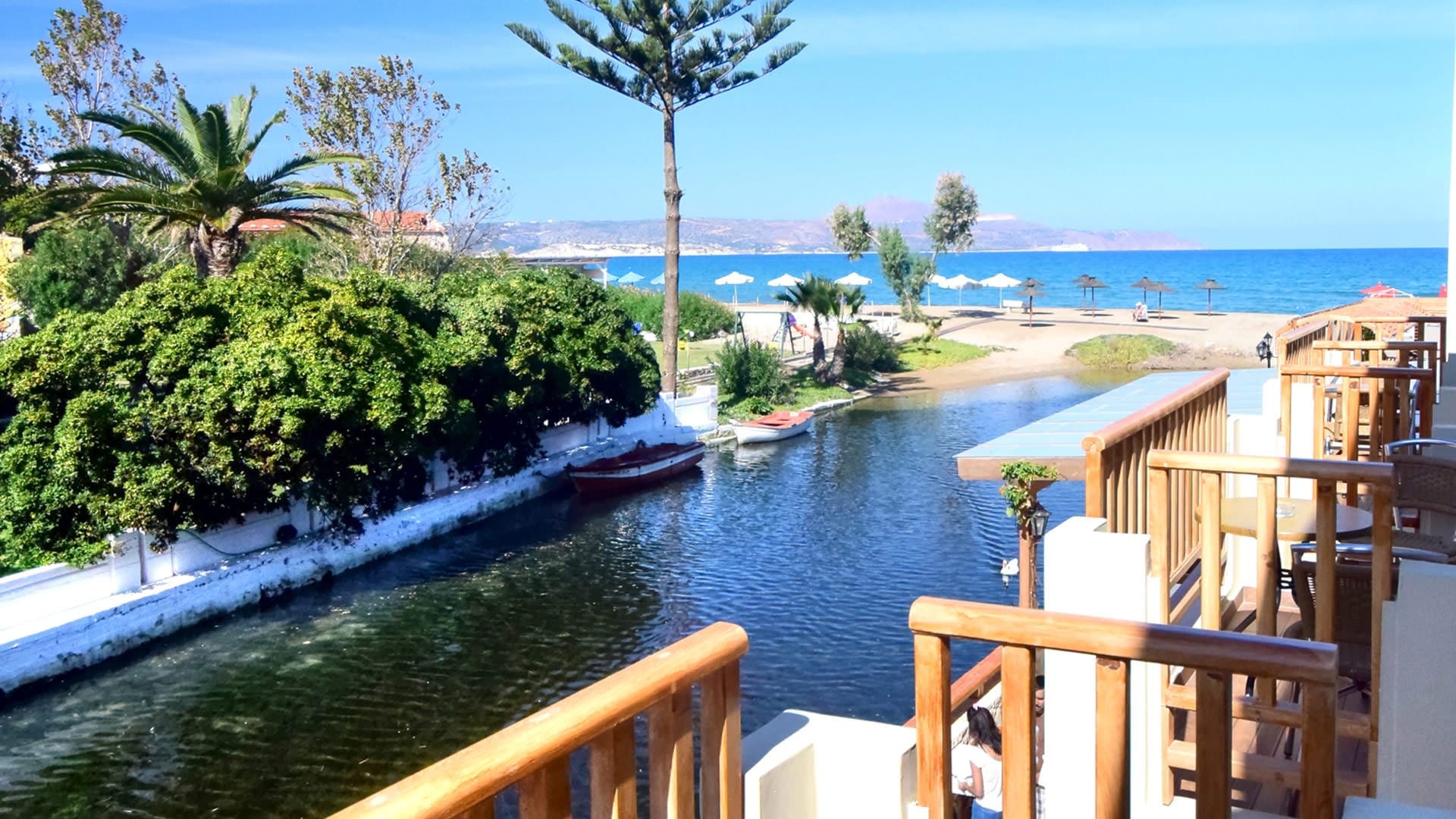 a body of water with trees and a beach in the background